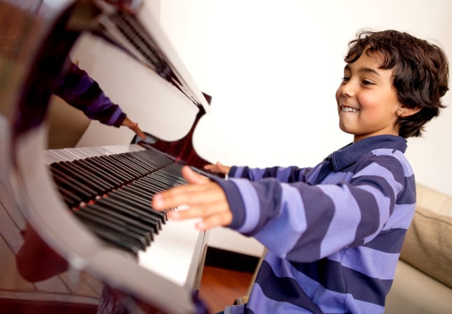 Boy looking very excited about taking piano lessons